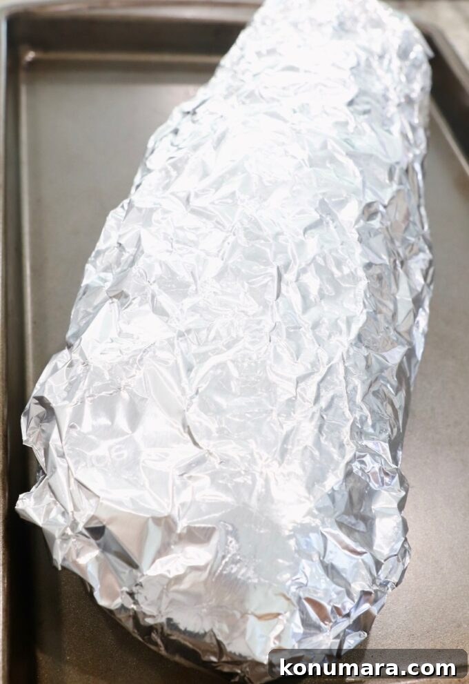 Crispy Garlic Bread with Herbed Butter 9 garlic bread wrapped in foil on baking sheet