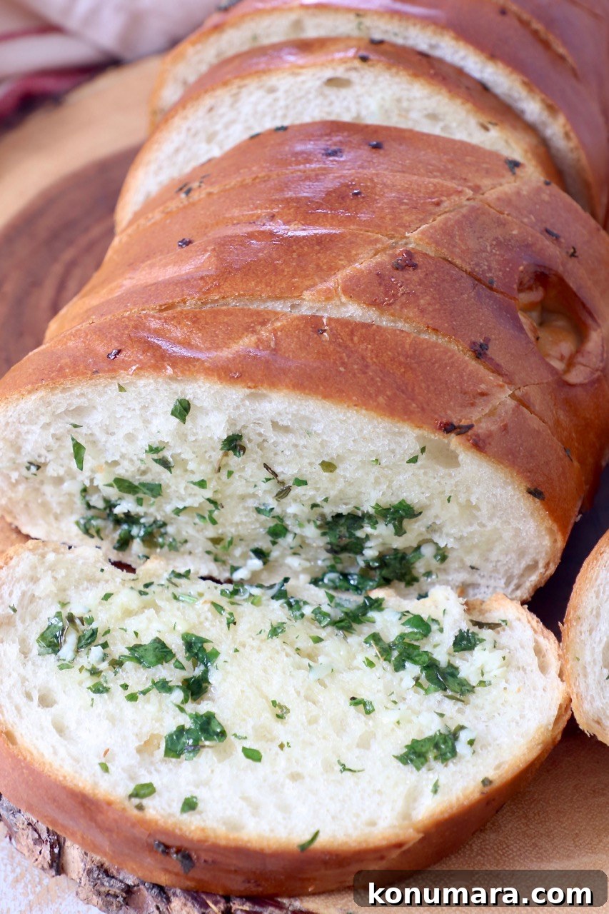 Crispy Garlic Bread with Herbed Butter 10 sliced loaf of garlic bread on wood cutting board