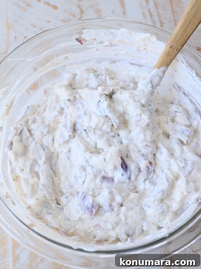 french onion dip mixed up in glass bowl with spatula