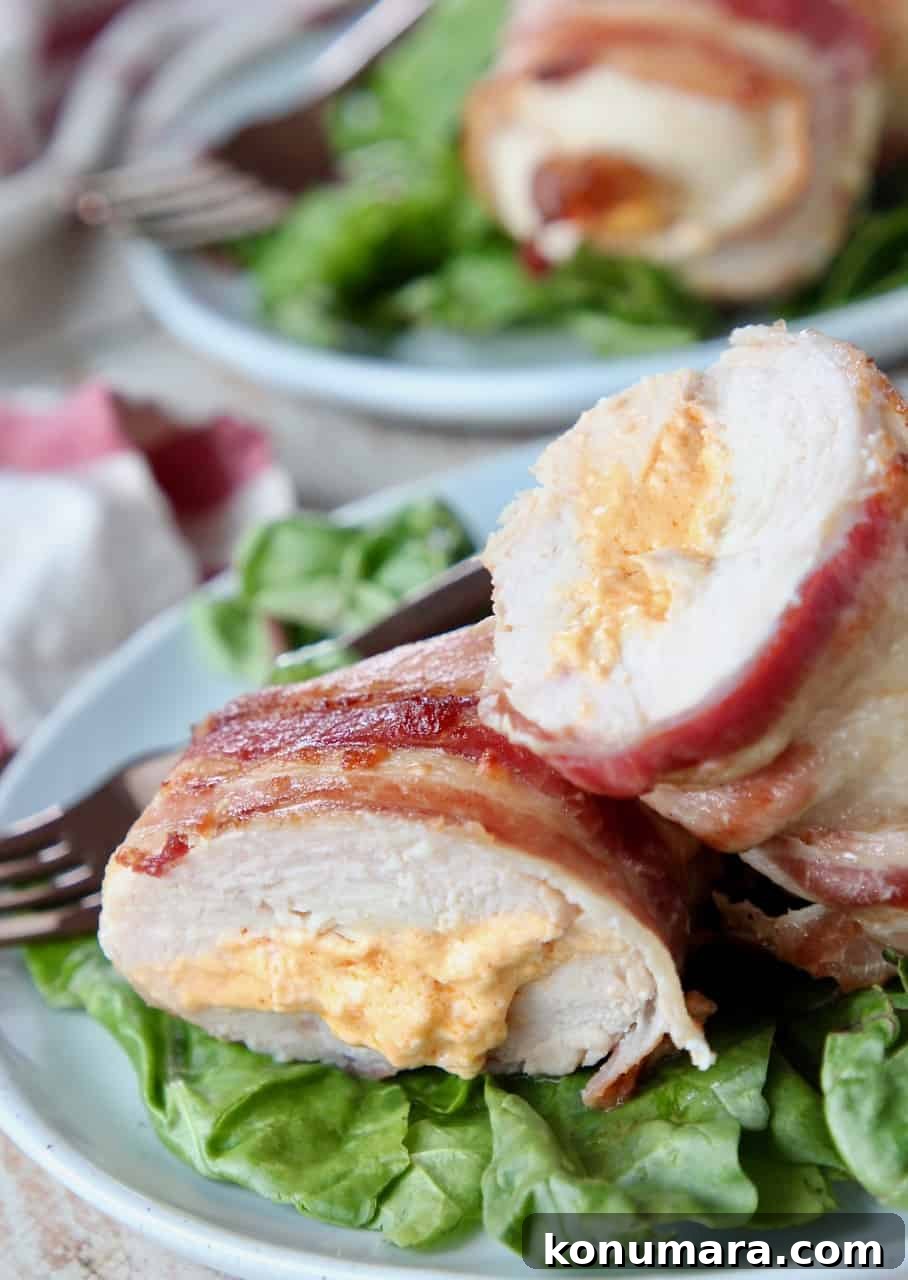 Juicy Bacon-Wrapped Stuffed Chicken Breasts Recipe 2 Sliced stuffed chicken breast on plate with salad