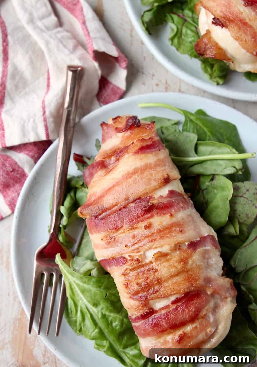 Juicy Bacon-Wrapped Stuffed Chicken Breasts Recipe 4 Bacon wrapped chicken breast on plate with fork and salad