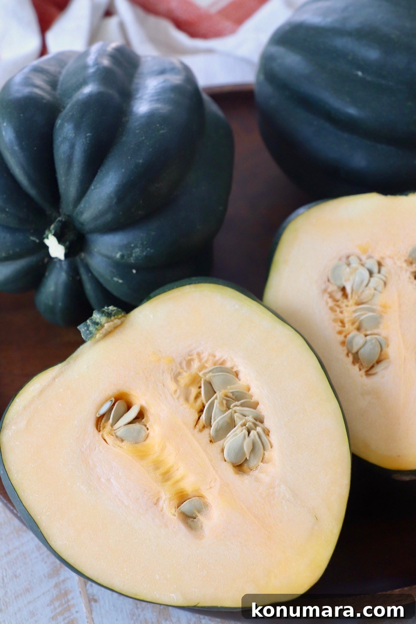 raw acorn squash whole and cut in half on wood serving tray