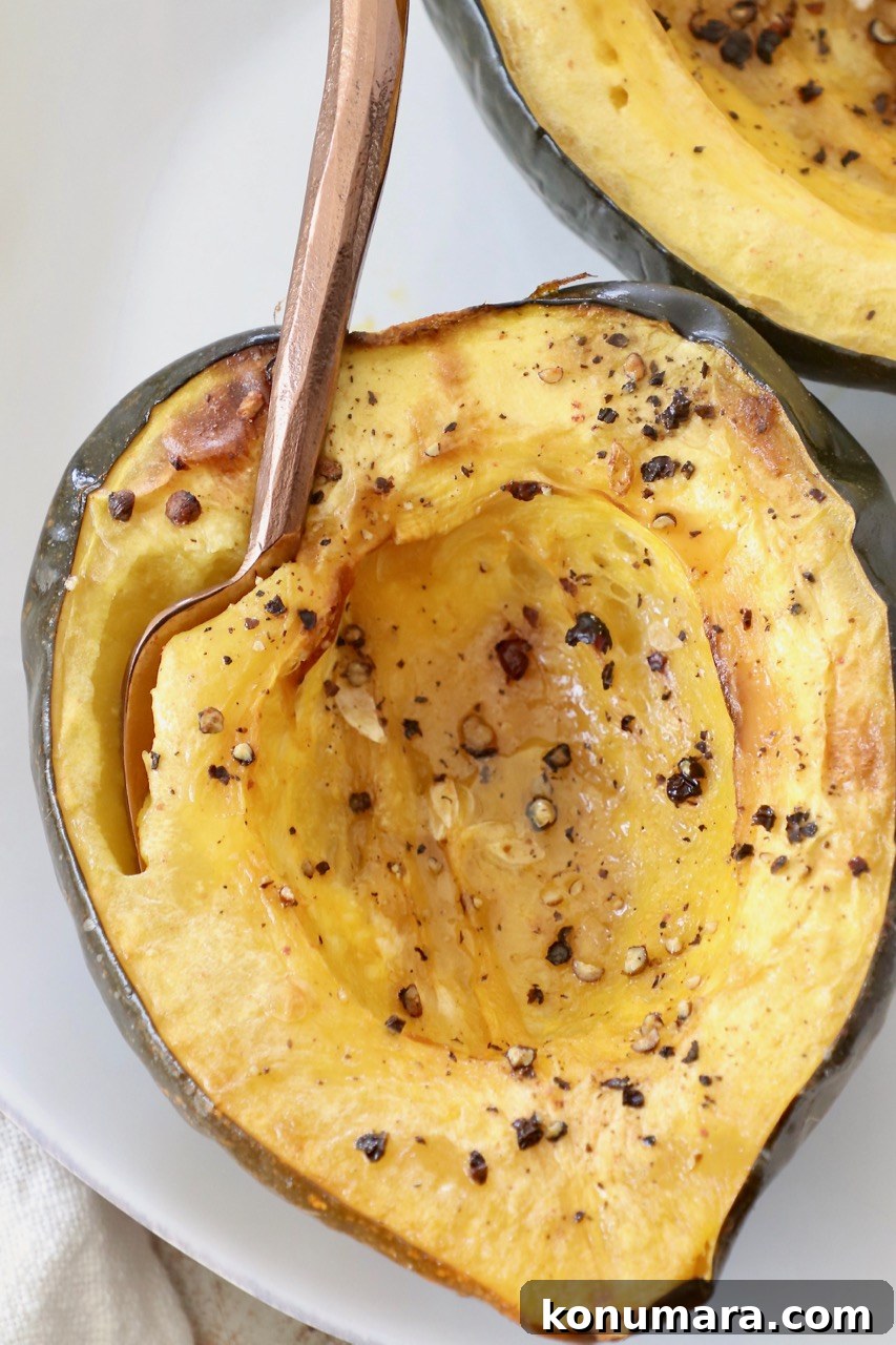 roasted acorn squash cut in half on plate with fork