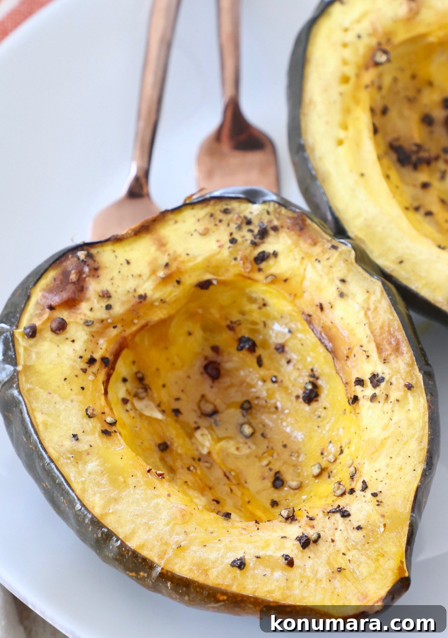 roasted acorn squash cut in half on plate with two forks
