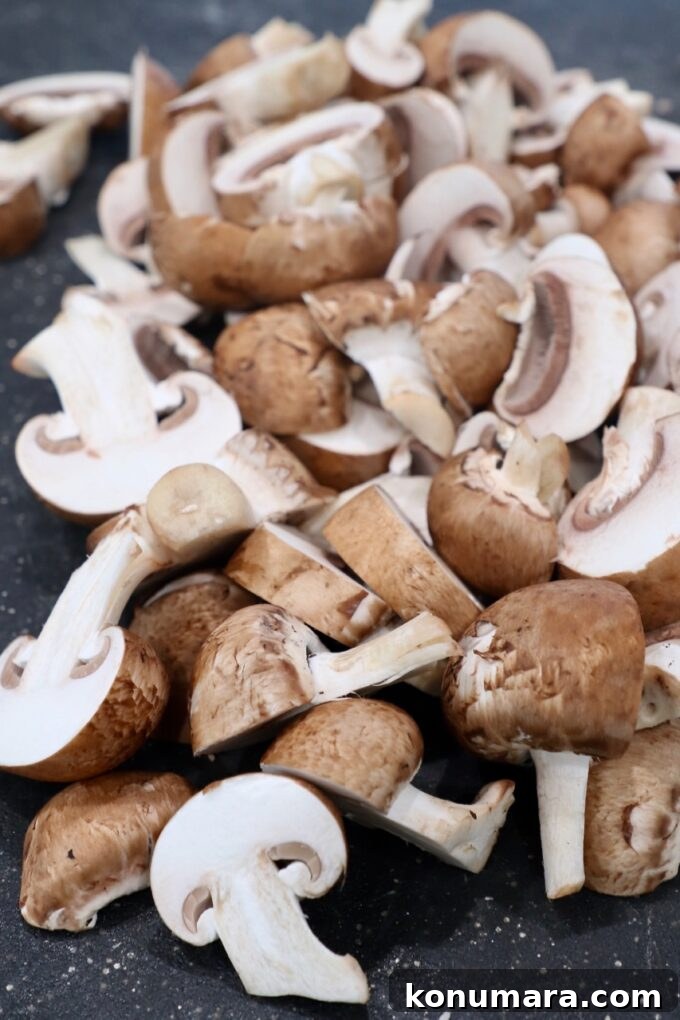 Garlic Butter Sauteed Mushrooms with Herbs 4 sliced mushrooms on cutting board