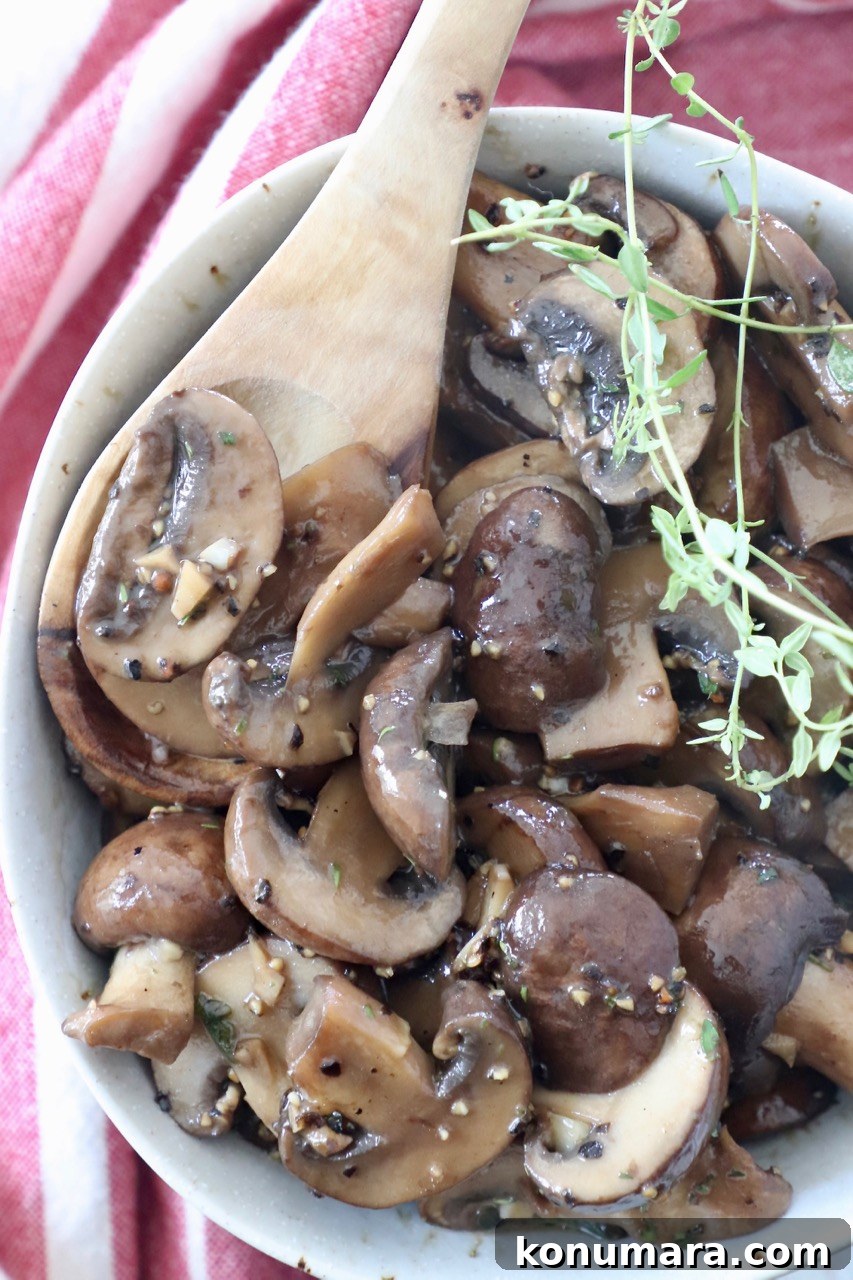 Garlic Butter Sauteed Mushrooms with Herbs 8 sauteed mushrooms in bowl with spoon