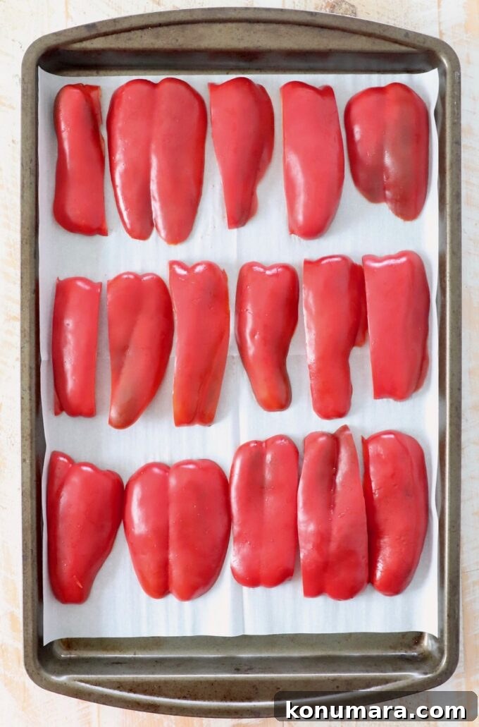 slices of red bell pepper on parchment lined baking sheet
