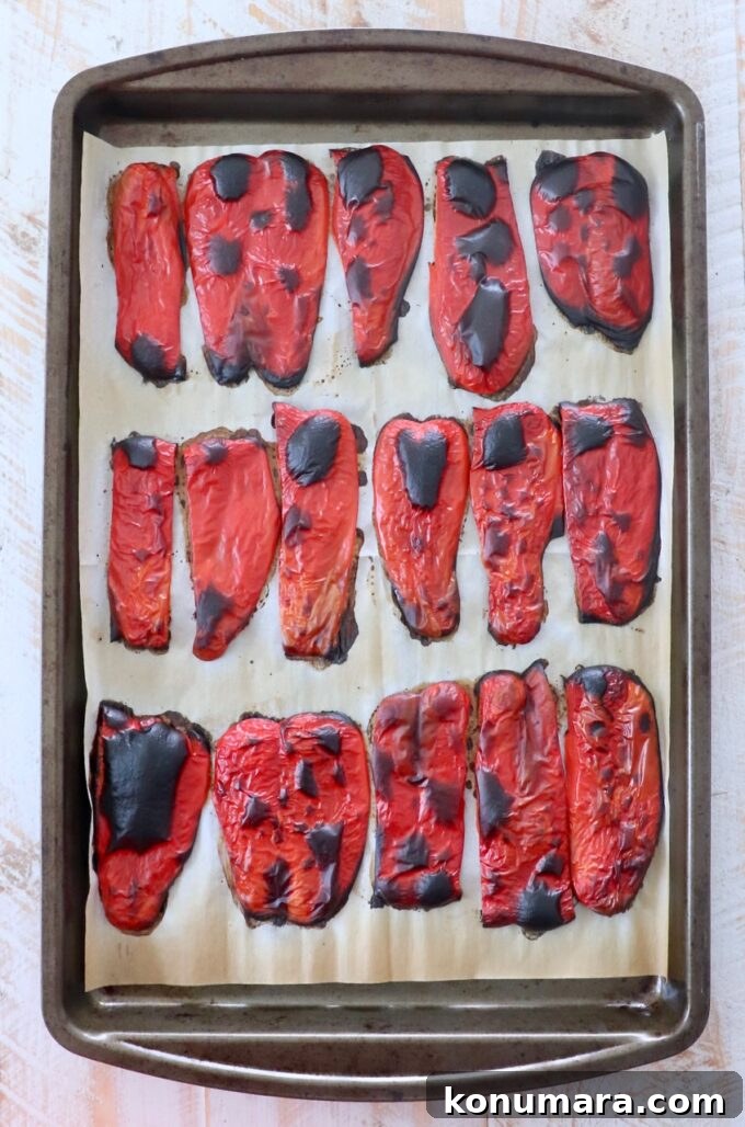roasted red pepper slices on parchment lined baking sheet
