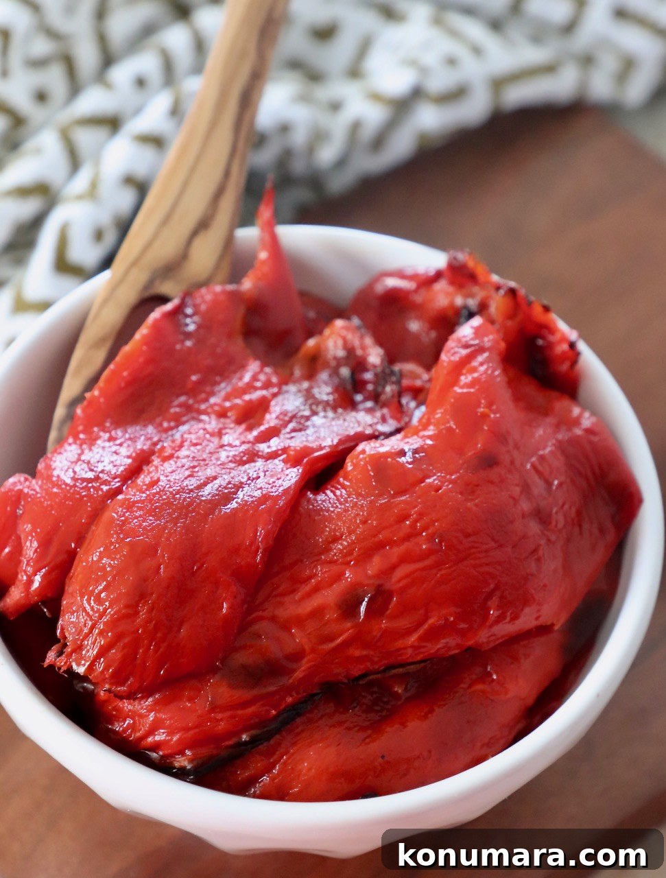 roasted red peppers in bowl with wooden fork