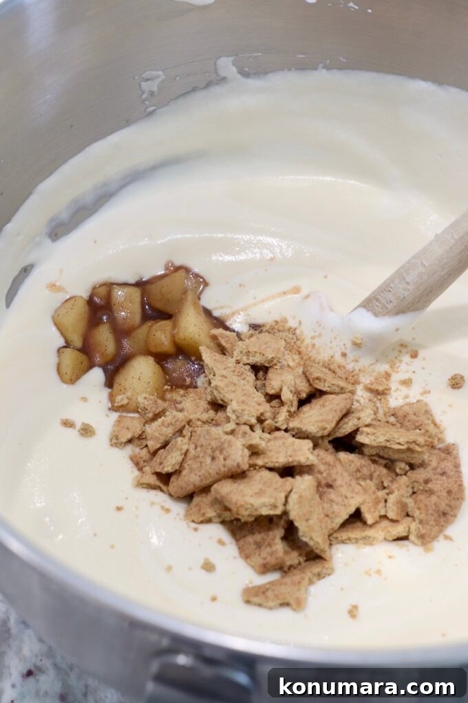 crumbled cookies and apple pie filling mixed into heavy cream in bowl
