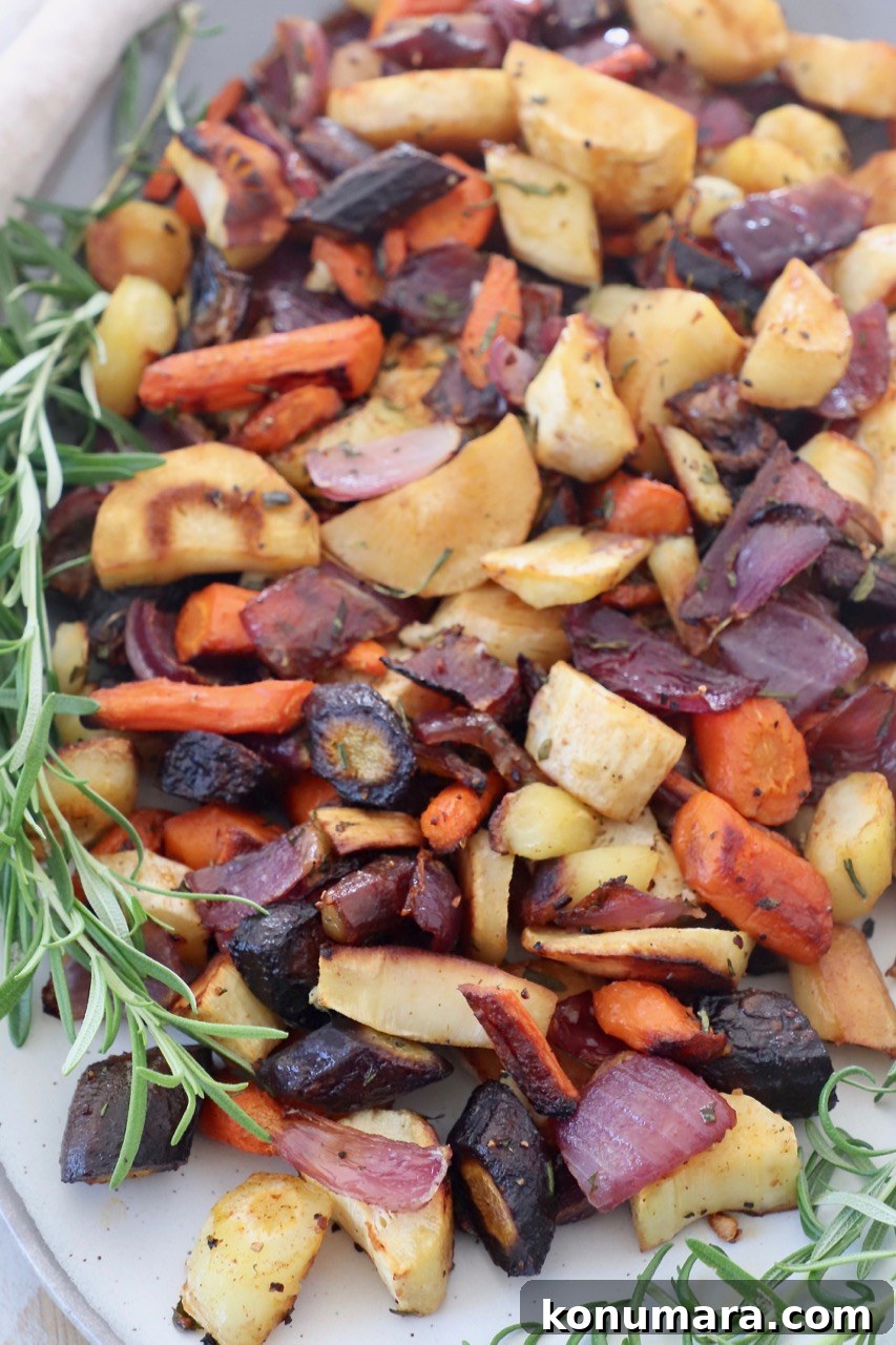 Oven-Roasted Root Vegetables with Garlic and Herbs 7 Roasted cubed vegetables on a plate with rosemary sprigs