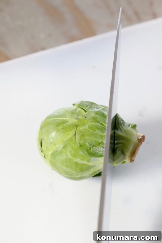 How to Shred Brussels Sprouts for Salads and Slaws 3 knife cutting into brussel sprout on cutting board