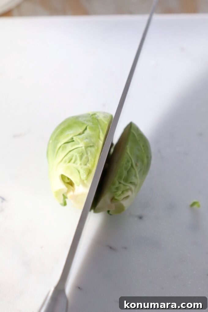 How to Shred Brussels Sprouts for Salads and Slaws 5 knife slicing brussel sprout in half on cutting board