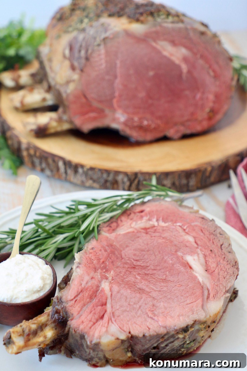 Oven-Roasted Bone-In Prime Rib with Garlic and Rosemary 2 slice of prime rib on the bone on plate and whole prime rib on cutting board behind it