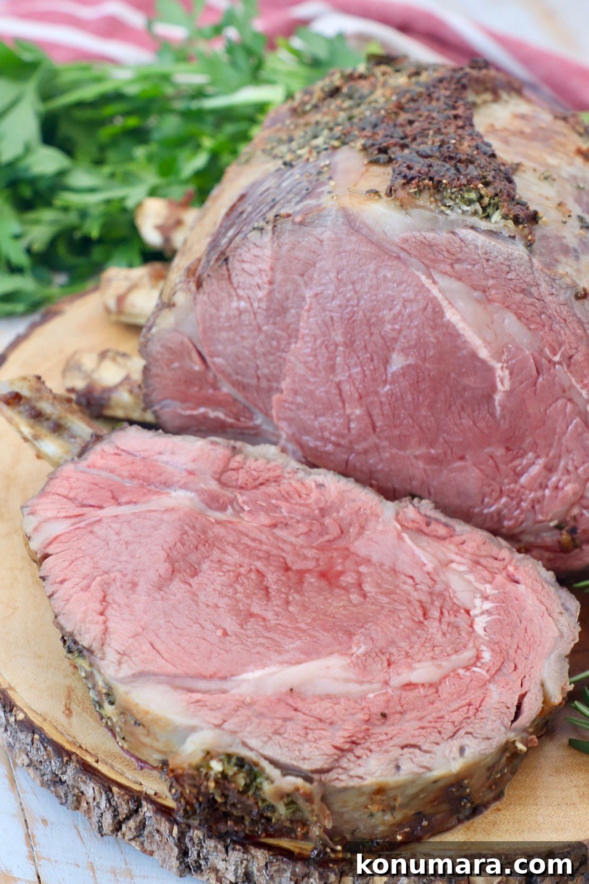 Oven-Roasted Bone-In Prime Rib with Garlic and Rosemary 8 bone in prime rib on wood cutting board with slice cut off of the meat