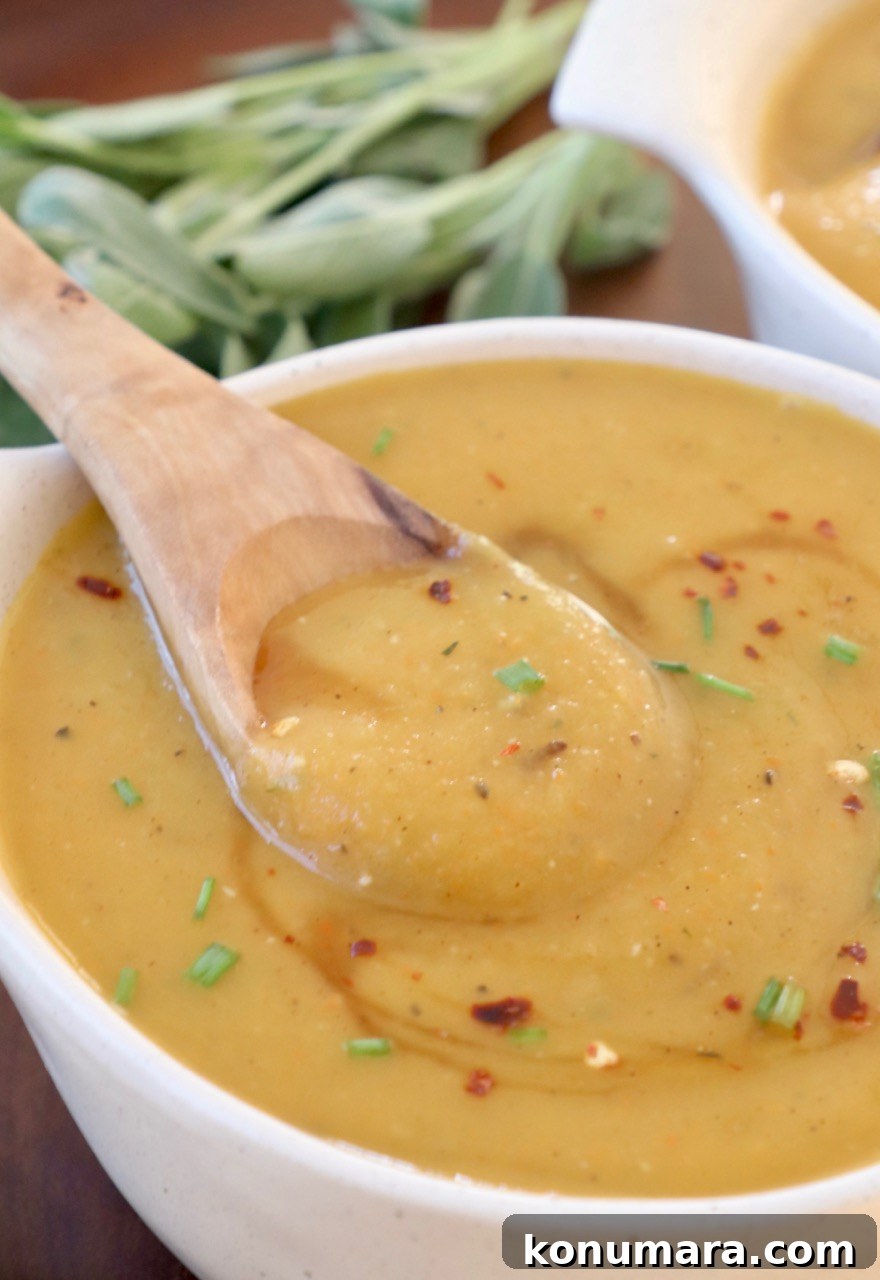 Creamy Roasted Acorn Squash Soup Recipe 2 acorn squash soup in bowl with wooden spoon