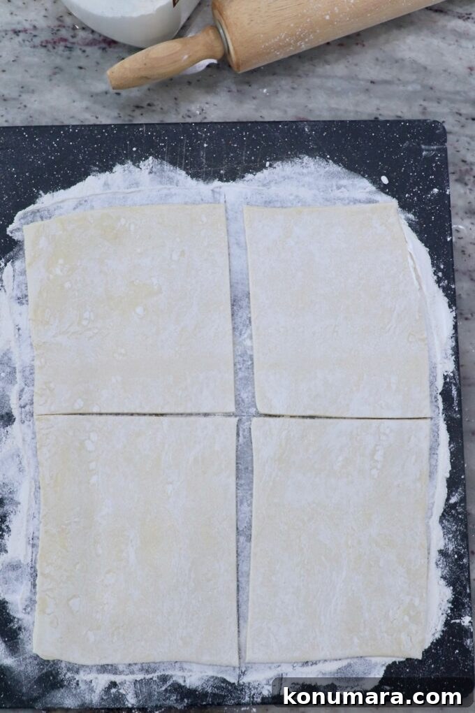 Classic Flaky Apple Danish with Cinnamon Filling 5 sheet of puff pastry dough cut into 4 squares on cutting board