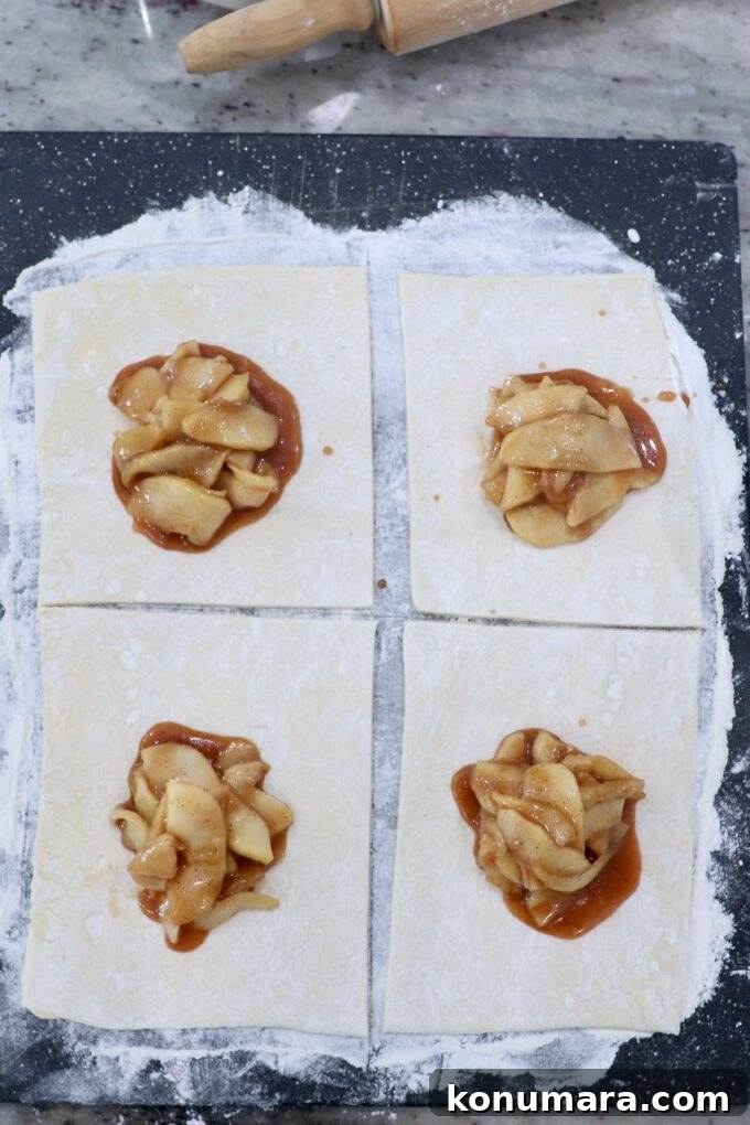 Classic Flaky Apple Danish with Cinnamon Filling 6 puff pastry sheet of dough on cutting board, topped with apple pie filling