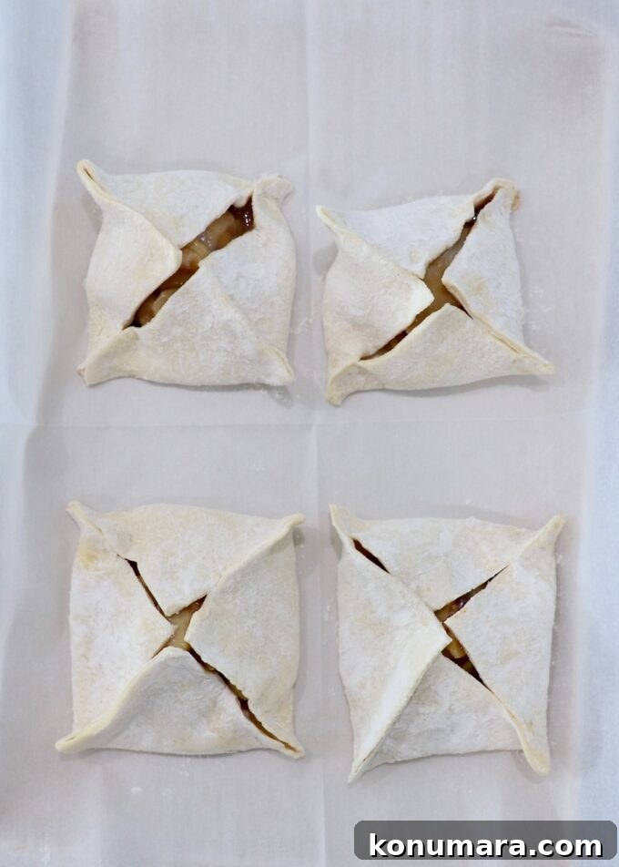 Classic Flaky Apple Danish with Cinnamon Filling 7 four uncooked apple danish on parchment paper