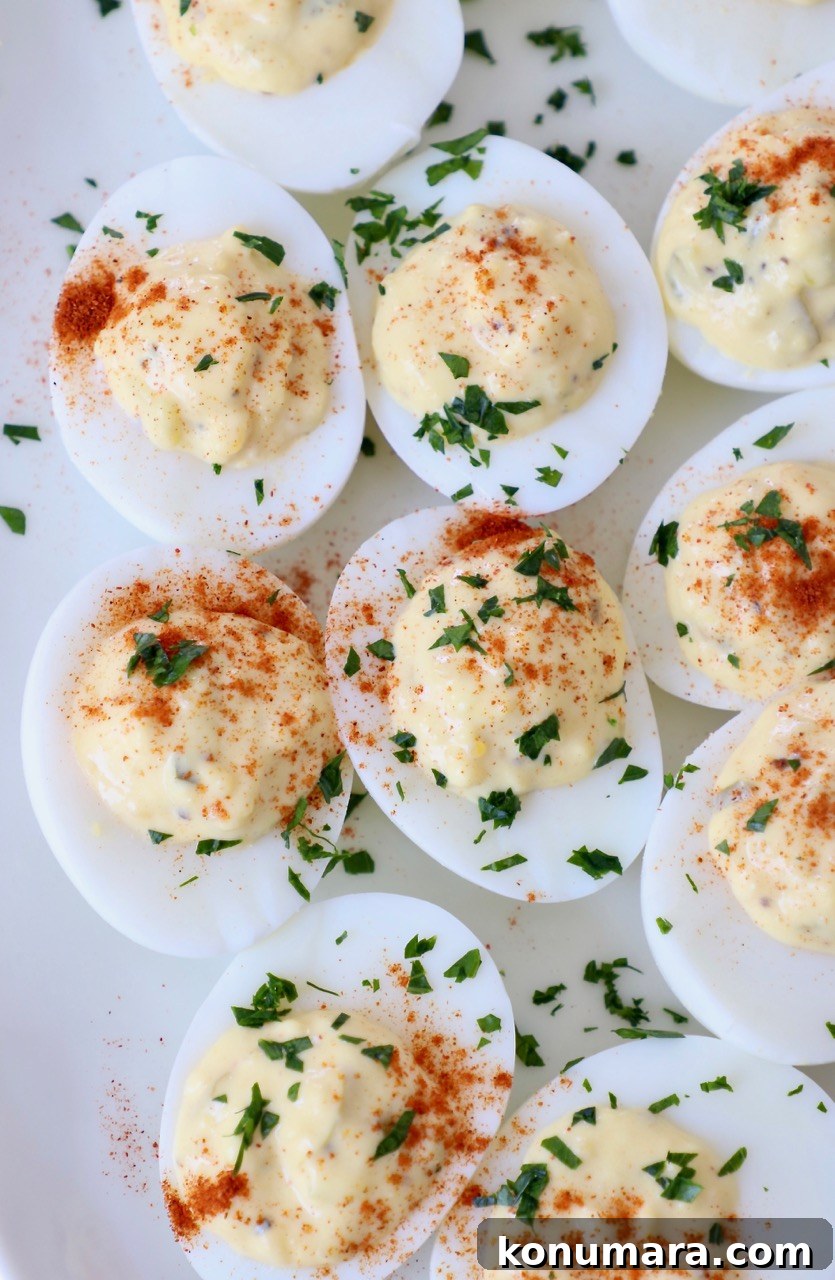 prepared deviled eggs with relish on plate topped with fresh chopped parsley
