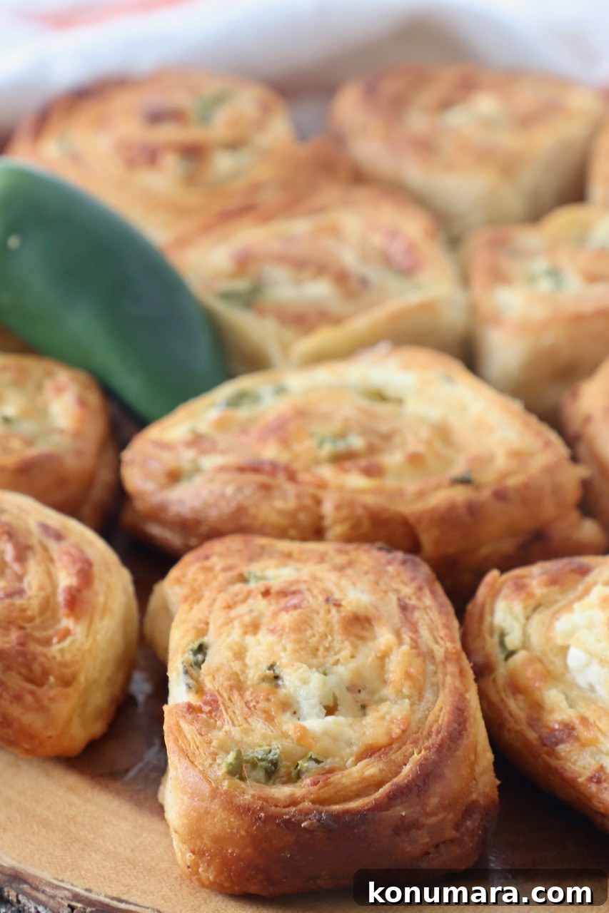 Cheesy Jalapeno Popper Crescent Rolls 2 jalapeno popper crescent rolls on wood serving board