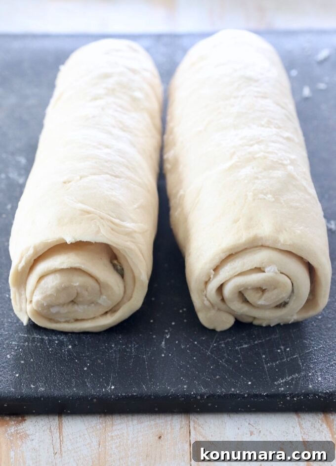 Cheesy Jalapeno Popper Crescent Rolls 9 rolled up crescent roll dough on cutting board
