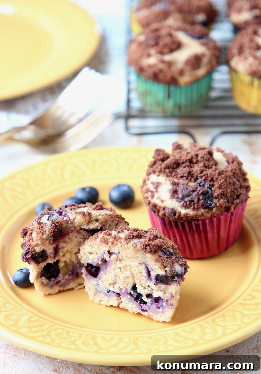 Decadent Blueberry Cream Cheese Muffins with Chocolate Crumble 5 Blueberry Cream Cheese Muffins with Fresh Blueberries on Yellow Plate