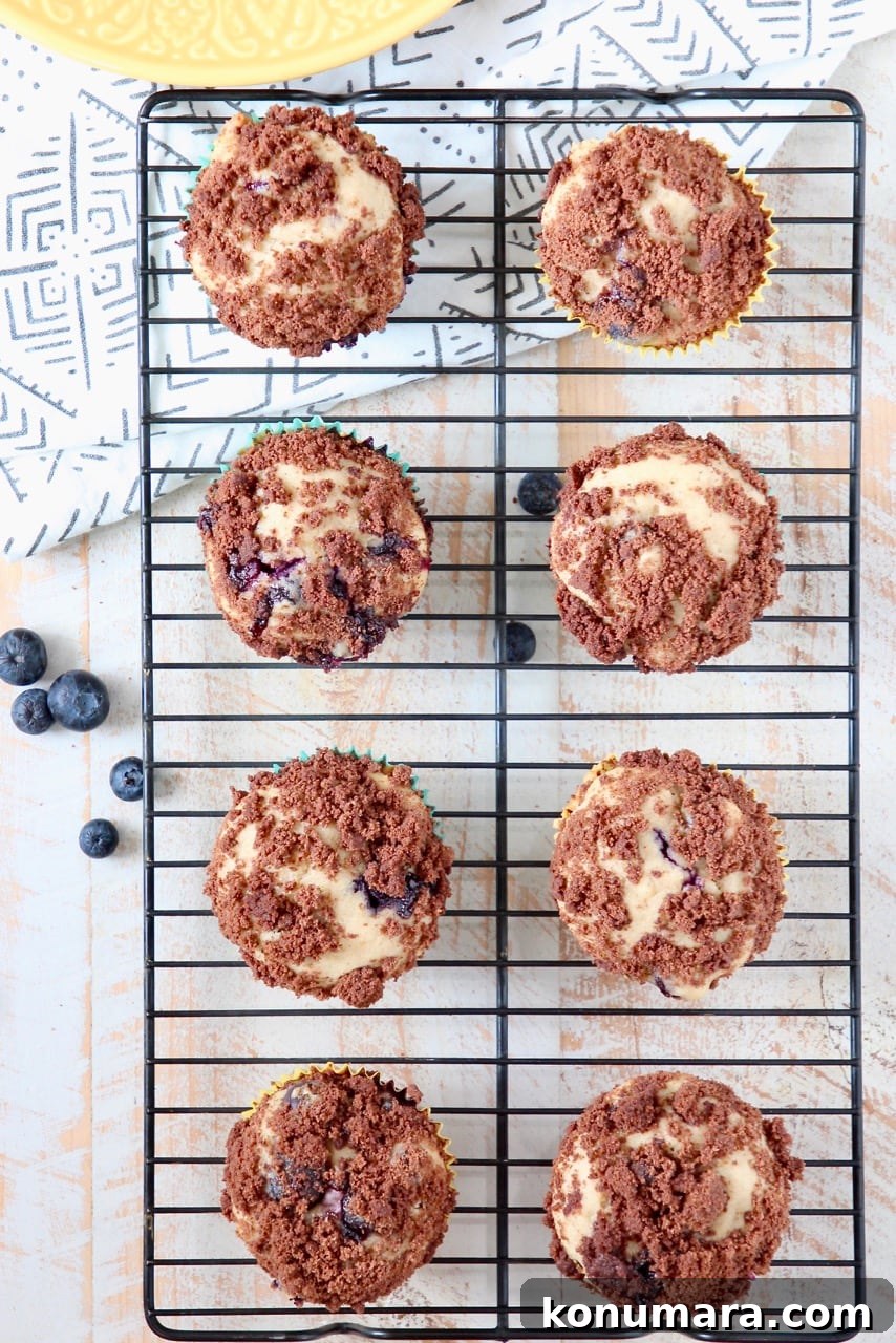 Decadent Blueberry Cream Cheese Muffins with Chocolate Crumble 7 Blueberry Cream Cheese Muffins with Chocolate Crumble on Wire Baking Rack