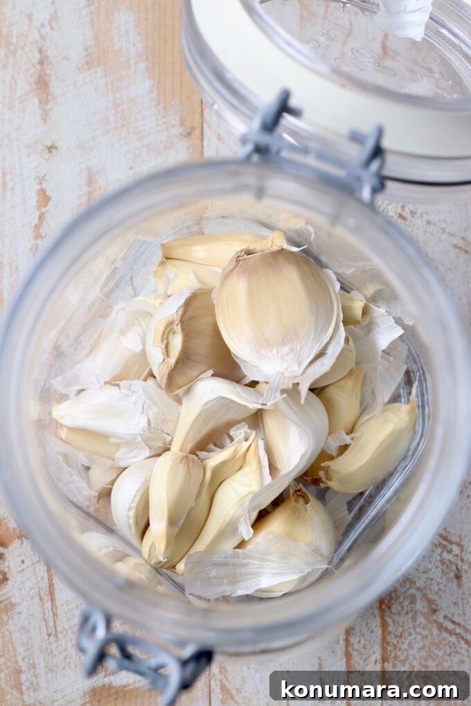 unpeeled garlic cloves in glass jar with lid