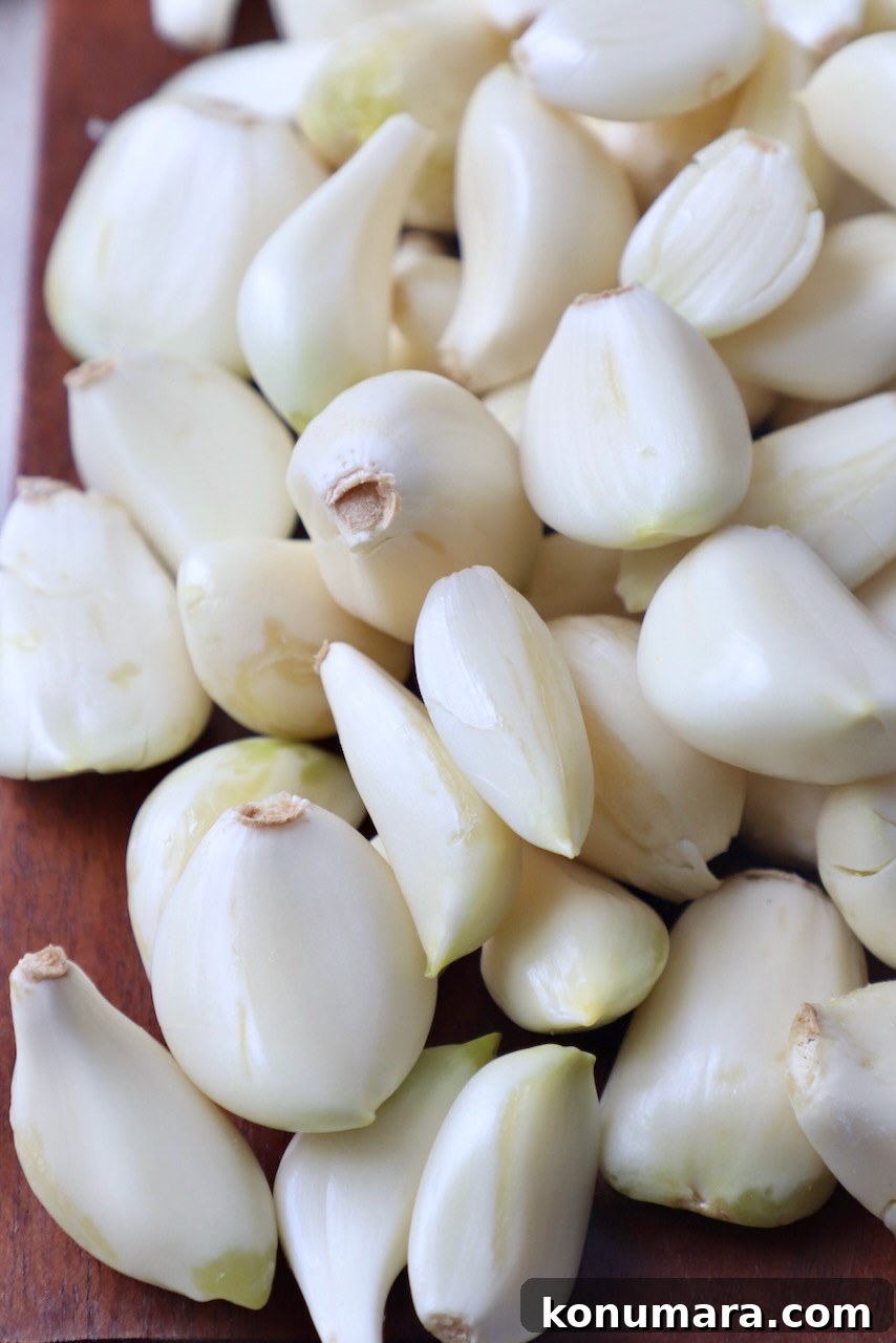 peeled cloves of garlic on brown cutting board