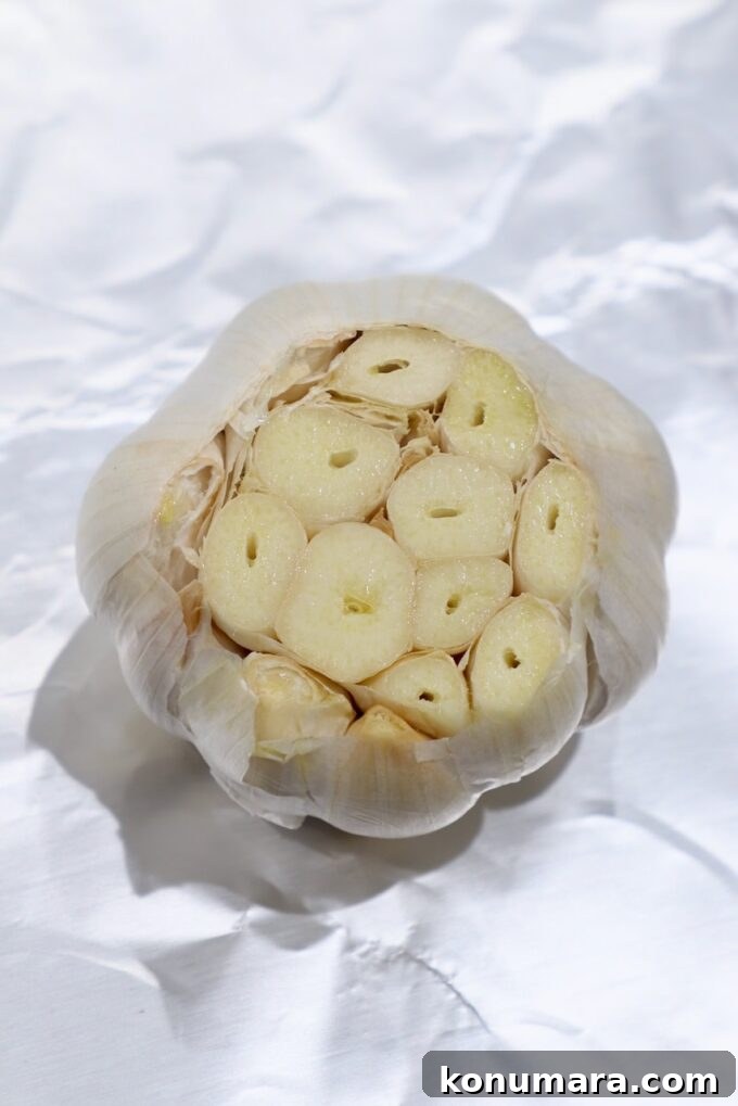 head of garlic with cloves exposed on piece of foil