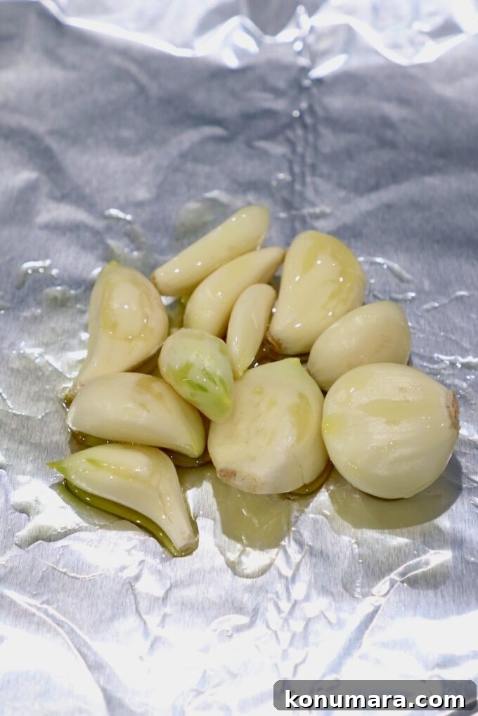 peeled garlic cloves on foil tossed in oil