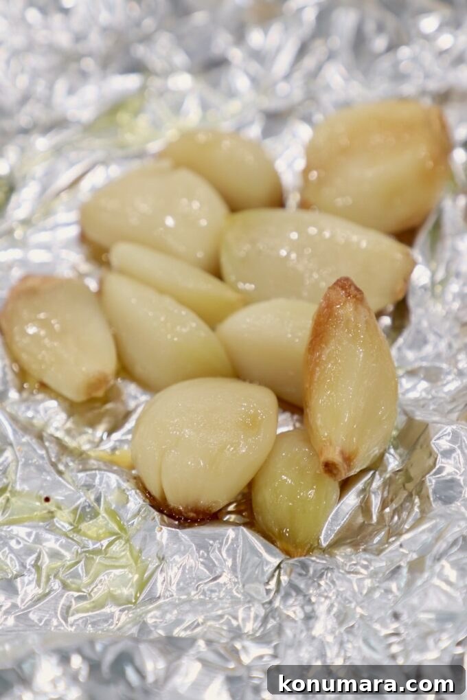 roasted garlic cloves on a piece of foil