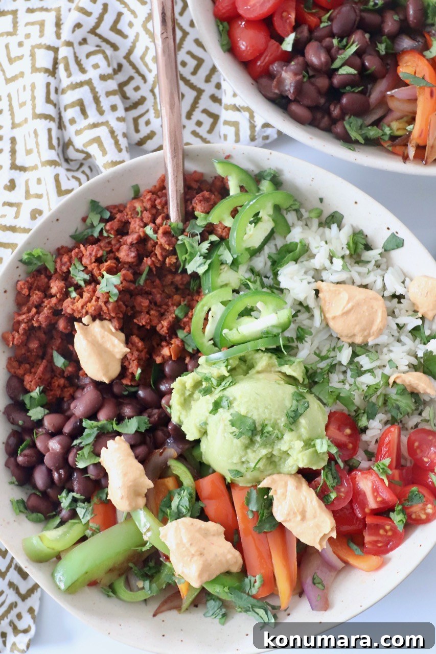 cooked rice, vegetables and soy chorizo in bowl with guacamole and chipotle sauce