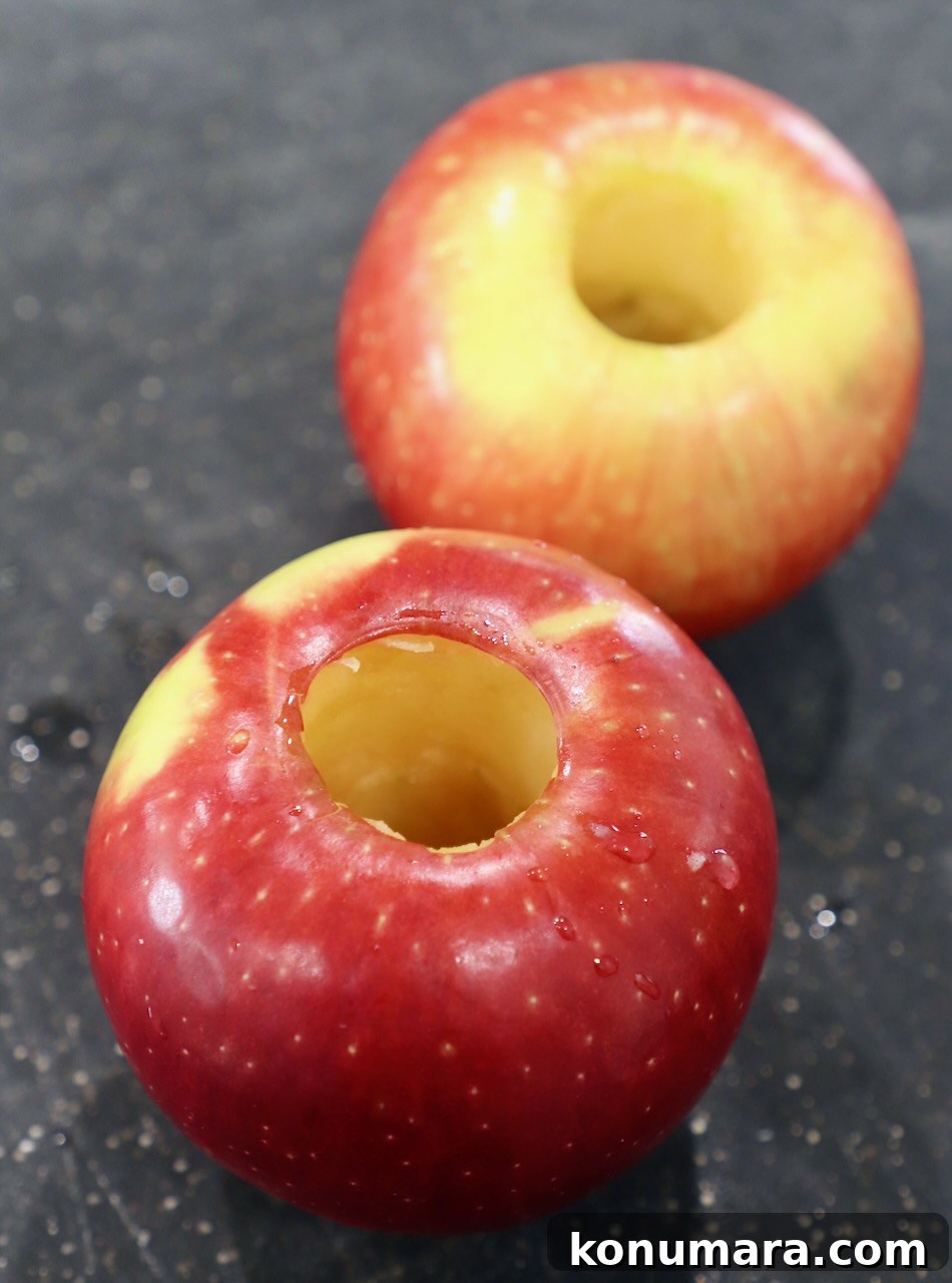 two cored apples on cutting board 