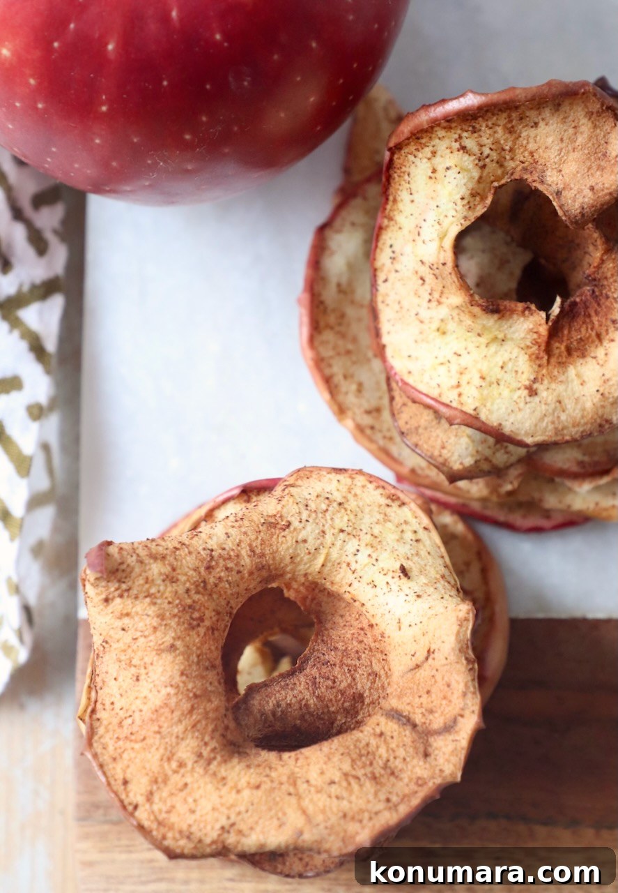 apple chips stacked up on cutting board