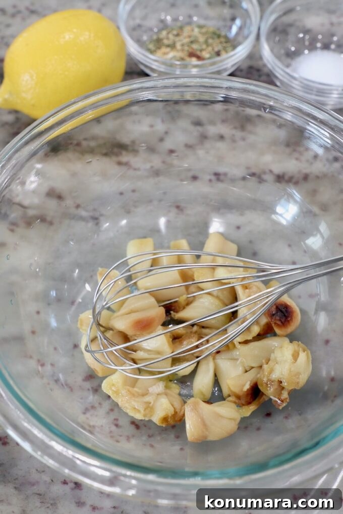 Creamy Roasted Garlic Dip Recipe 4 roasted garlic in glass bowl with whisk