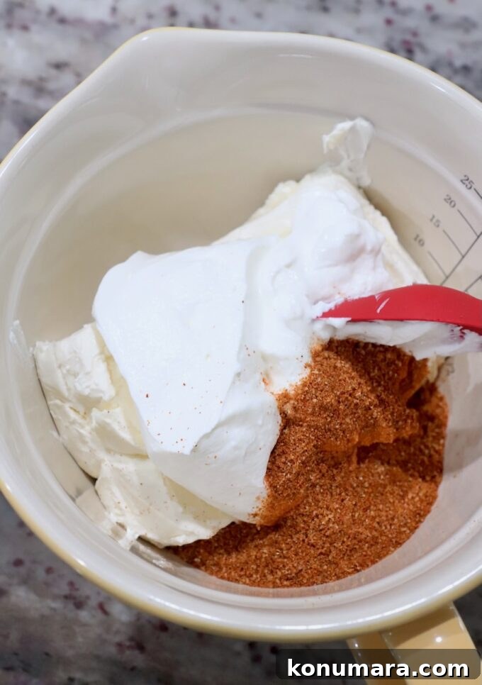 cream cheese, sour cream and fajita seasoning in bowl