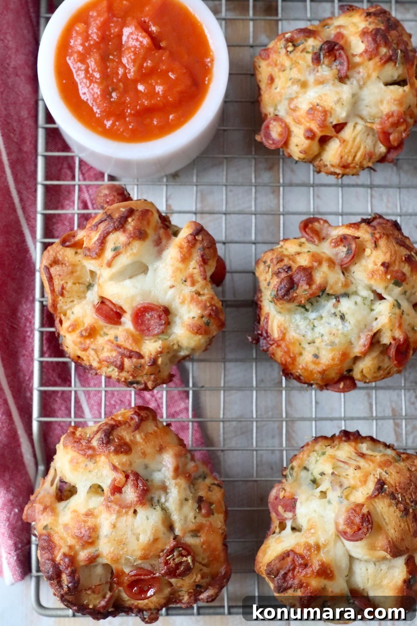 pizza rolls on wire rack with bowl or marinara sauce