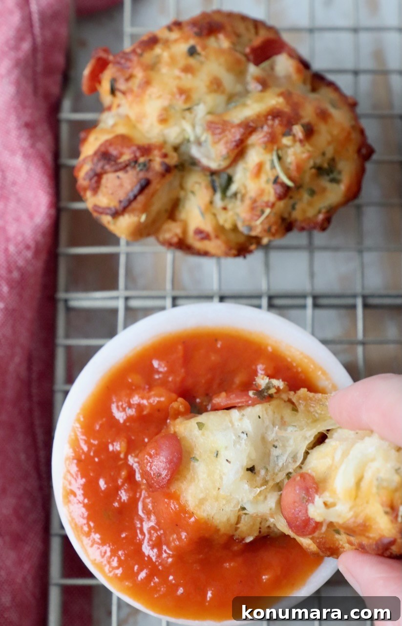 hand dipping pizza roll into bowl or marinara sauce