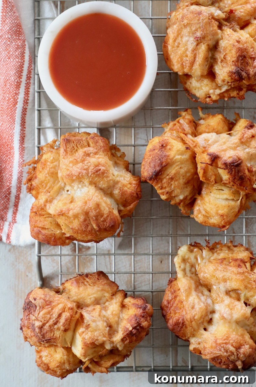 Pull-Apart Buffalo Chicken Rolls Recipe 2 pull apart rolls on wire rack with small bowl of buffalo sauce on the side