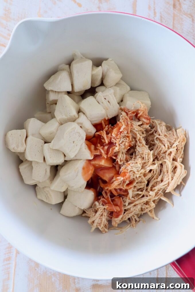 Pull-Apart Buffalo Chicken Rolls Recipe 5 diced refrigerated biscuits, shredded chicken and buffalo sauce in mixing bowl