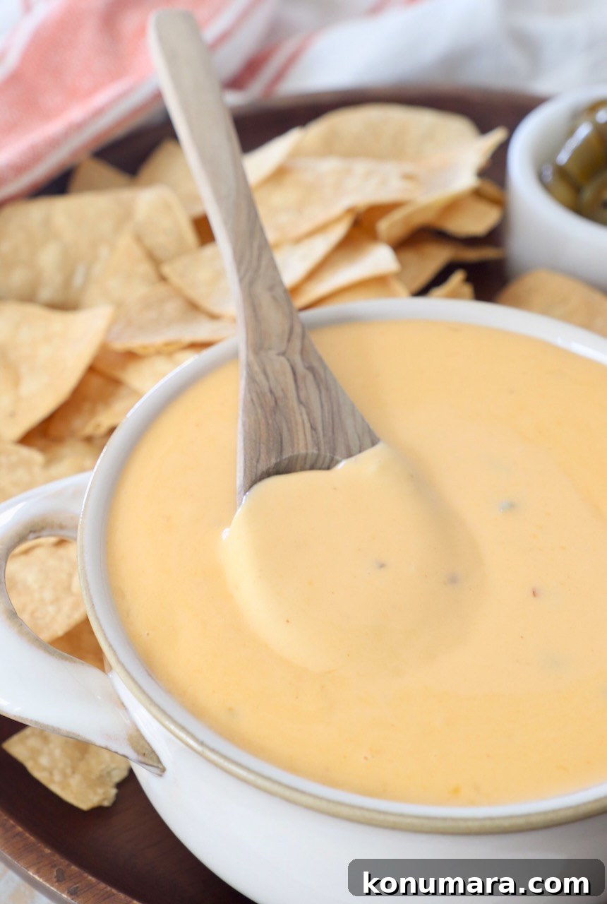 Homemade Nacho Cheese Sauce for Dips and Tacos 2 nacho cheese sauce in bowl with spoon