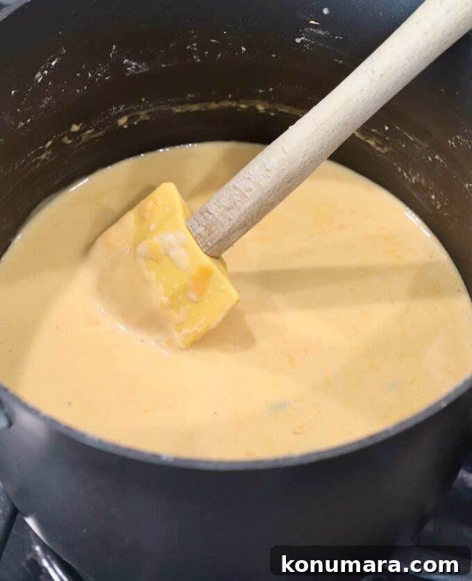 Homemade Nacho Cheese Sauce for Dips and Tacos 7 cheese sauce in pan with spatula