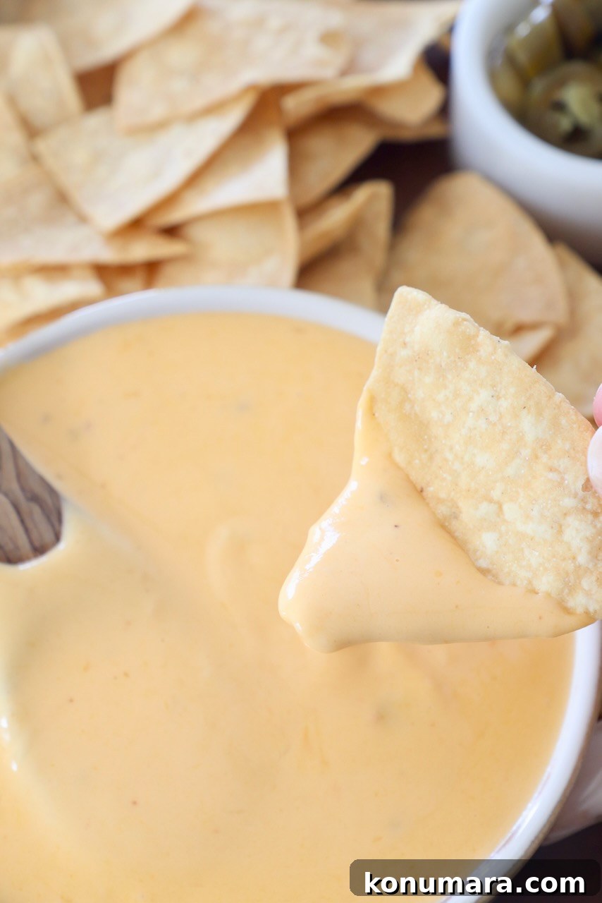 Homemade Nacho Cheese Sauce for Dips and Tacos 9 tortilla chip dipping up nacho cheese sauce