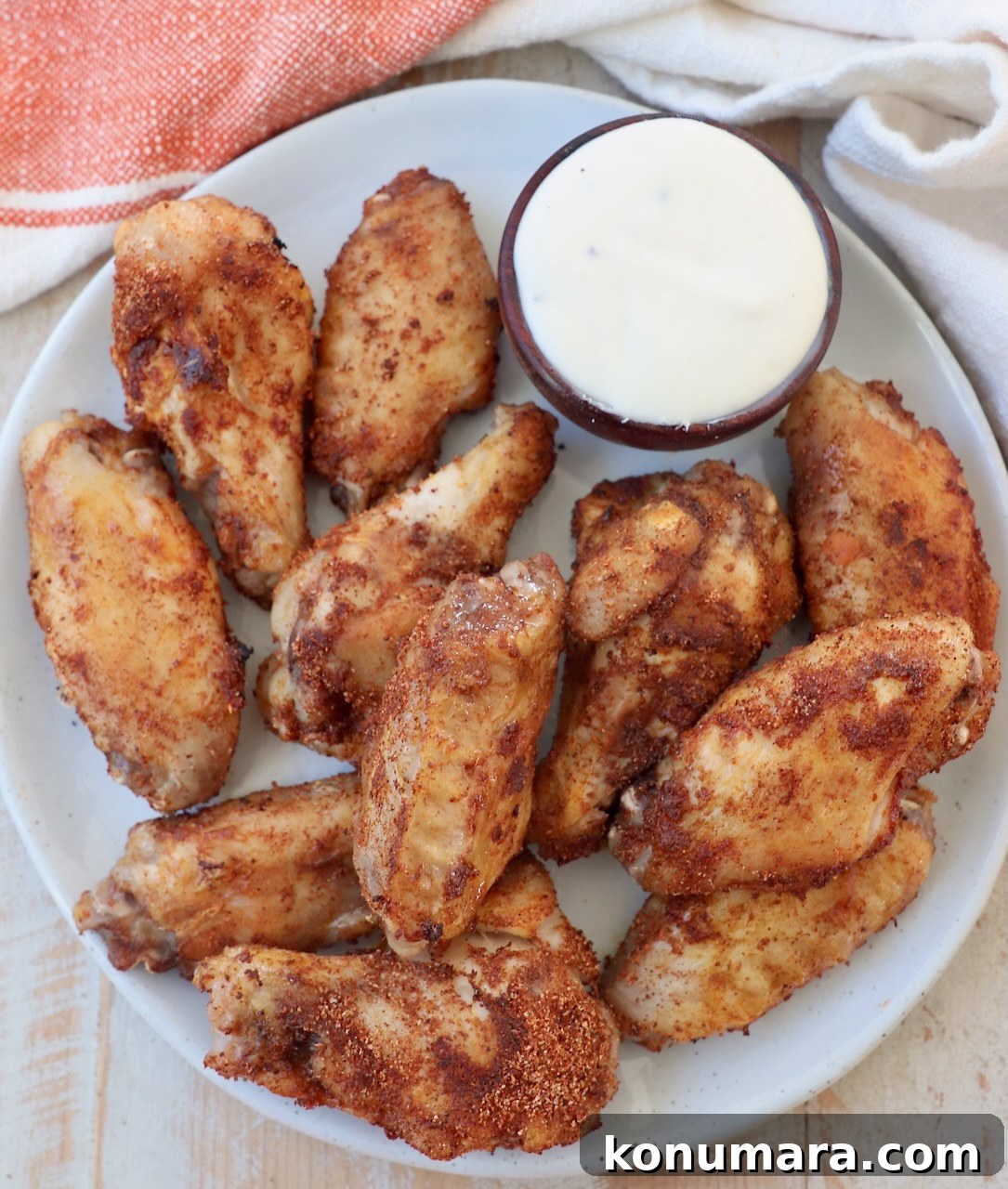 cooked chicken wings on plate with side of blue cheese dressing in small bowl