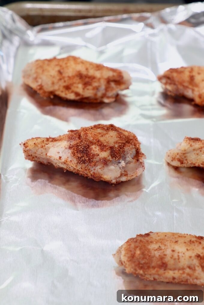 seasoned chicken wings on foil lined baking sheet