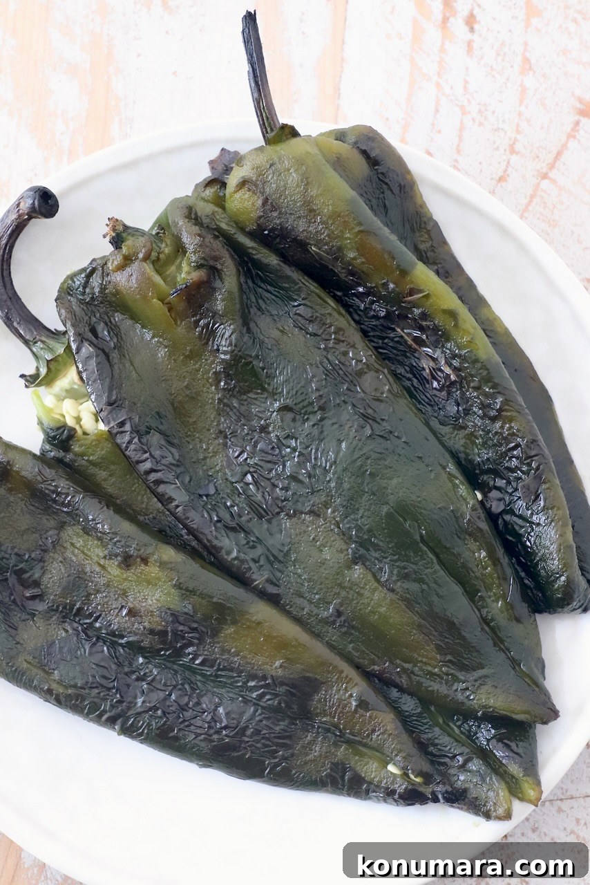How to Roast Poblano Peppers for Salsa and Stuffing 8 roasted poblano peppers on white plate