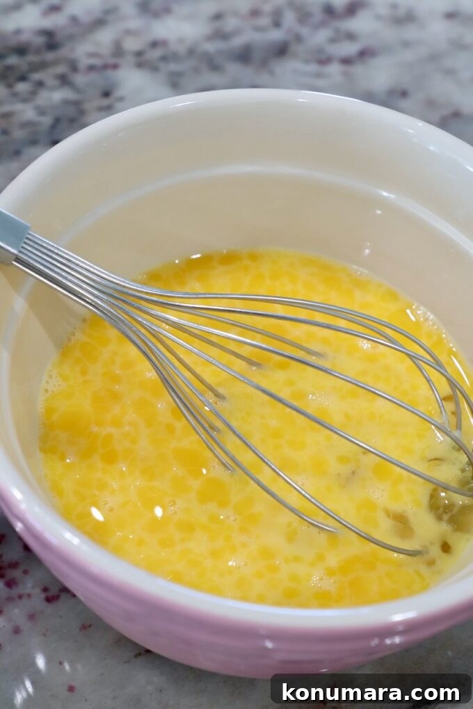 Classic Spanish Migas Recipe with Chorizo and Fried Eggs 4 whisked eggs in mixing bowl with large whisk