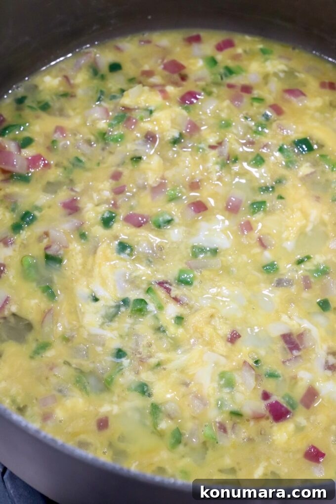 Classic Spanish Migas Recipe with Chorizo and Fried Eggs 6 whisked eggs in skillet with jalapenos and onions
